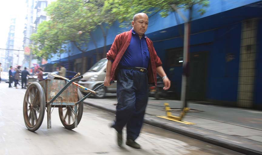 自行车上的音乐人生  他倒骑自行车吹奏口琴、弹吉他……